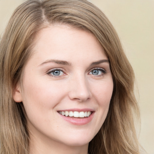 Joyful white young-adult female with long  brown hair and blue eyes