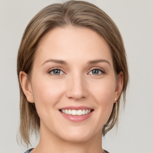 Joyful white young-adult female with medium  brown hair and grey eyes