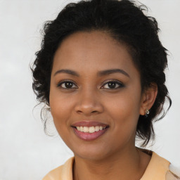 Joyful black young-adult female with long  brown hair and brown eyes