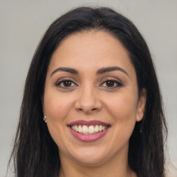 Joyful latino young-adult female with long  brown hair and brown eyes