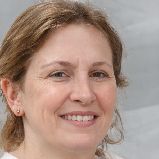 Joyful white adult female with medium  brown hair and grey eyes