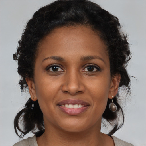 Joyful black young-adult female with medium  brown hair and brown eyes