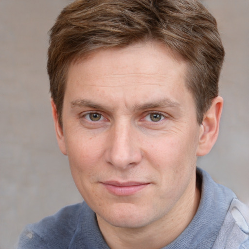 Joyful white adult male with short  brown hair and blue eyes