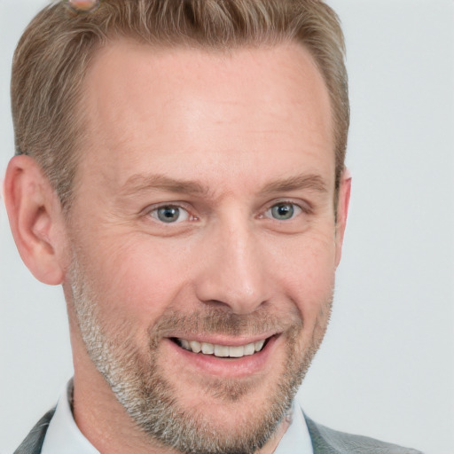 Joyful white adult male with short  brown hair and blue eyes