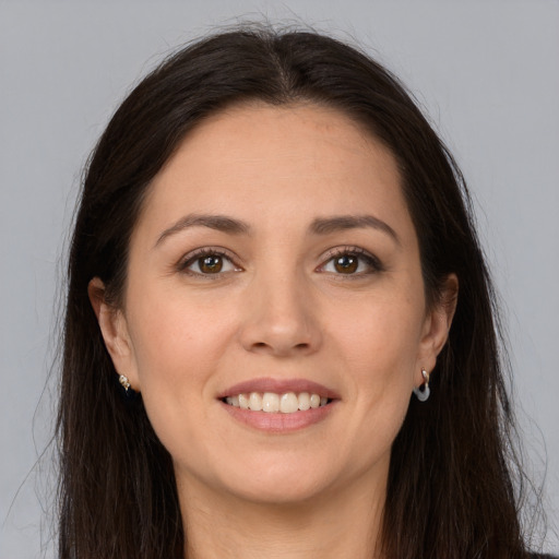 Joyful white young-adult female with long  brown hair and brown eyes