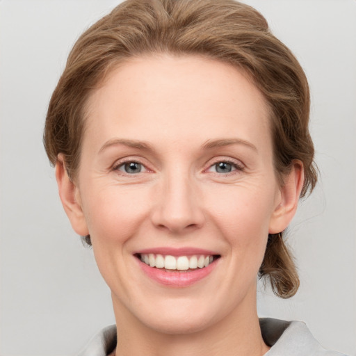 Joyful white young-adult female with short  brown hair and grey eyes