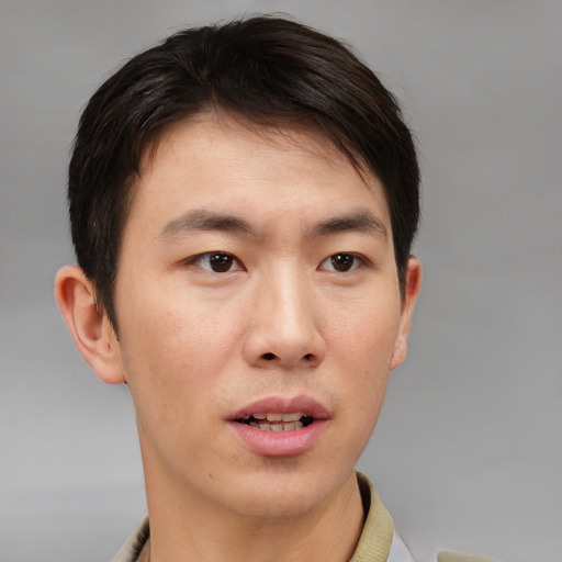 Joyful asian young-adult male with short  brown hair and brown eyes