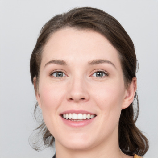 Joyful white young-adult female with medium  brown hair and grey eyes