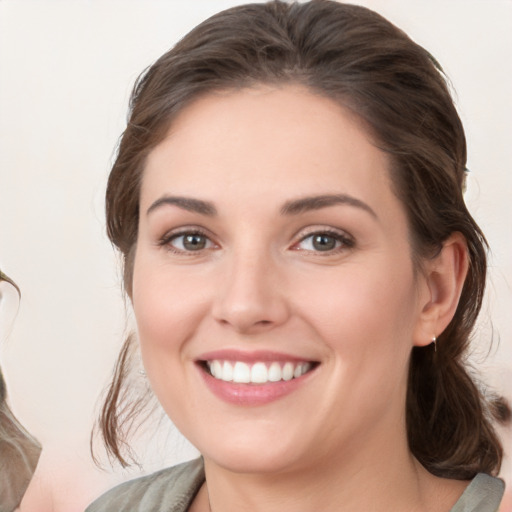 Joyful white young-adult female with medium  brown hair and grey eyes