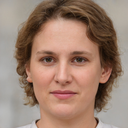 Joyful white young-adult female with medium  brown hair and green eyes