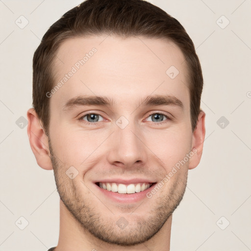 Joyful white young-adult male with short  brown hair and grey eyes