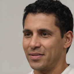 Joyful white adult male with short  black hair and brown eyes
