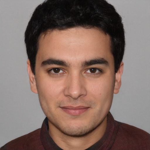 Joyful white young-adult male with short  black hair and brown eyes