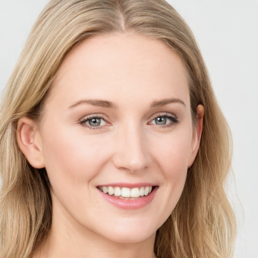 Joyful white young-adult female with long  brown hair and blue eyes