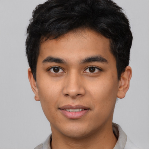 Joyful latino young-adult male with short  brown hair and brown eyes