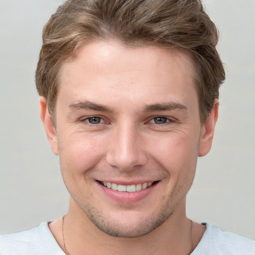 Joyful white young-adult male with short  brown hair and grey eyes