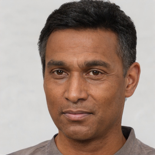 Joyful black adult male with short  black hair and brown eyes