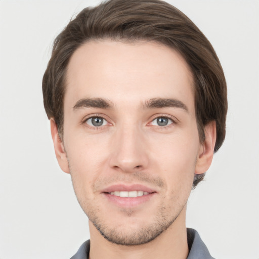 Joyful white young-adult male with short  brown hair and grey eyes