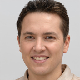 Joyful white young-adult male with short  brown hair and grey eyes