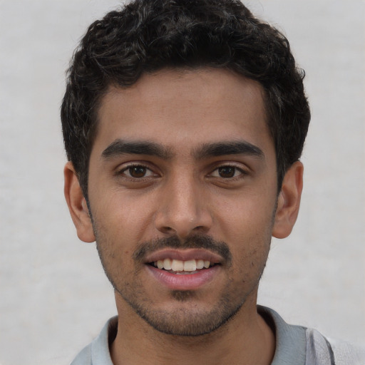 Joyful white young-adult male with short  black hair and brown eyes