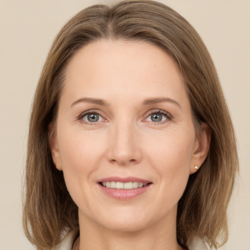 Joyful white adult female with medium  brown hair and grey eyes