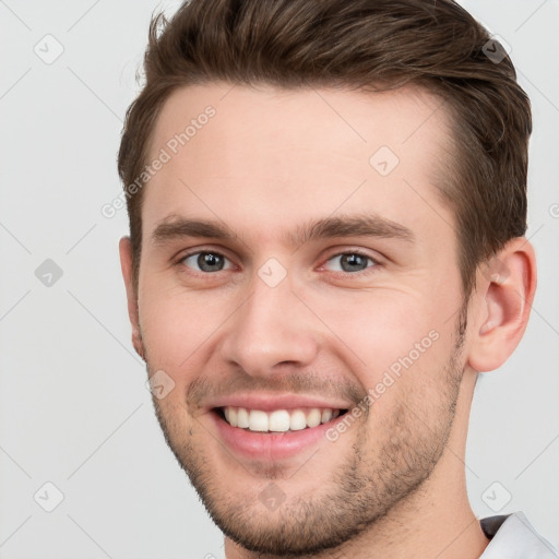 Joyful white young-adult male with short  brown hair and grey eyes