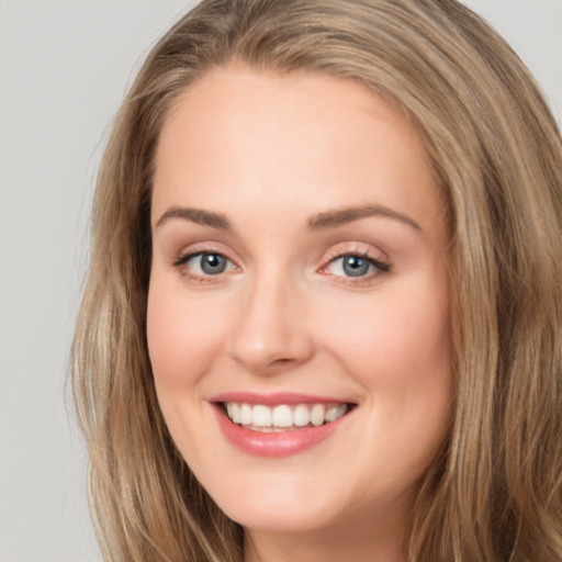 Joyful white young-adult female with long  brown hair and blue eyes