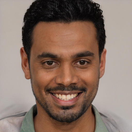 Joyful white young-adult male with short  black hair and brown eyes