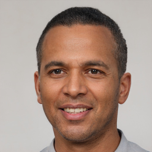 Joyful latino adult male with short  black hair and brown eyes