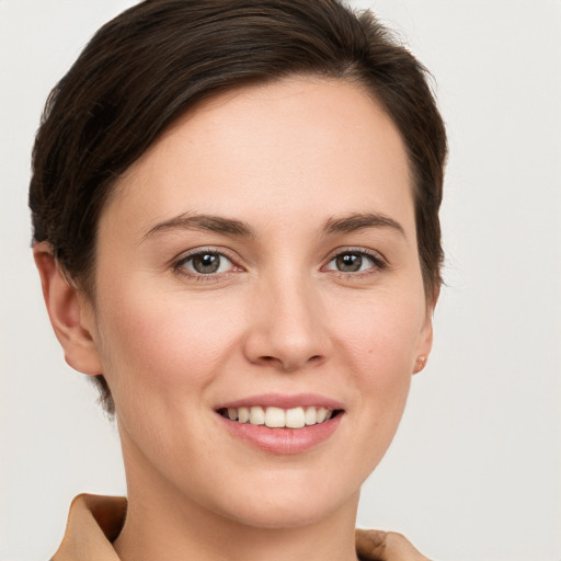 Joyful white young-adult female with short  brown hair and grey eyes