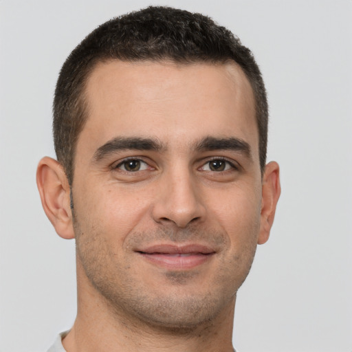 Joyful white young-adult male with short  brown hair and brown eyes