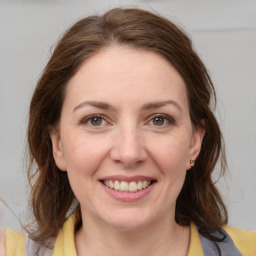 Joyful white young-adult female with medium  brown hair and grey eyes