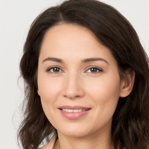 Joyful white young-adult female with long  brown hair and brown eyes