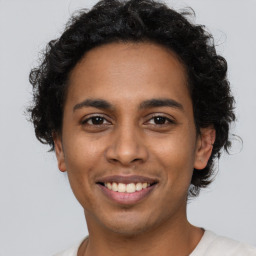 Joyful latino young-adult male with short  brown hair and brown eyes