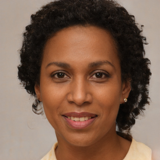 Joyful black adult female with short  brown hair and brown eyes