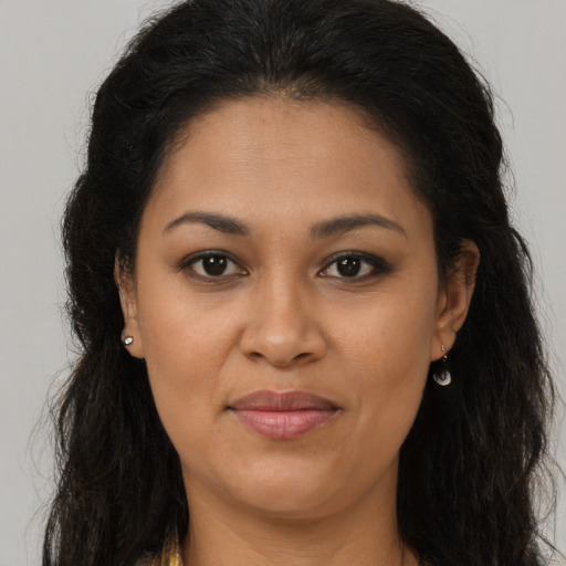 Joyful latino young-adult female with long  brown hair and brown eyes