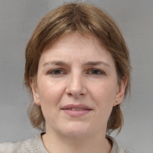 Joyful white young-adult female with medium  brown hair and blue eyes