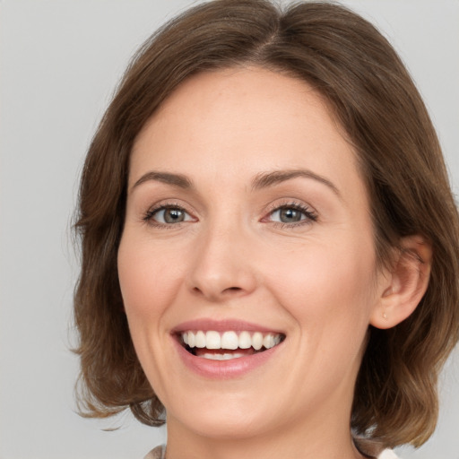 Joyful white young-adult female with medium  brown hair and green eyes