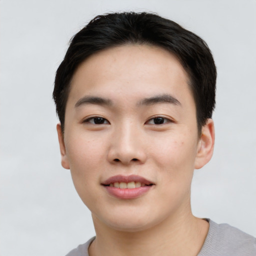 Joyful asian young-adult male with short  black hair and brown eyes