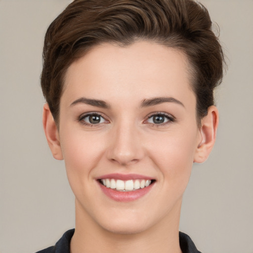 Joyful white young-adult female with short  brown hair and grey eyes