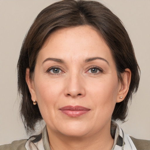 Joyful white adult female with medium  brown hair and brown eyes