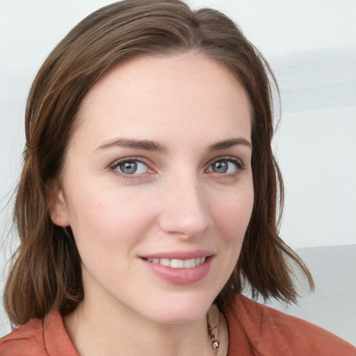 Joyful white young-adult female with medium  brown hair and blue eyes