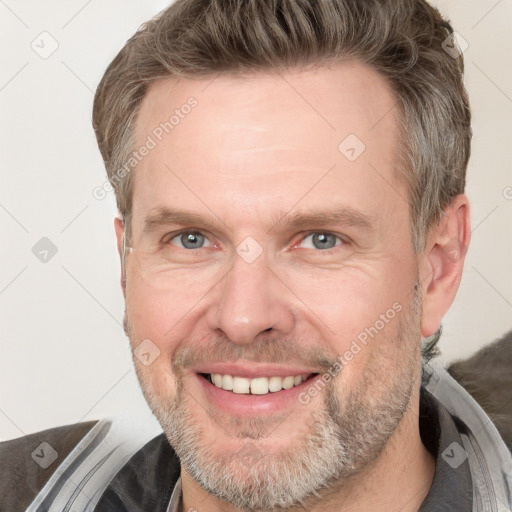 Joyful white adult male with short  brown hair and grey eyes