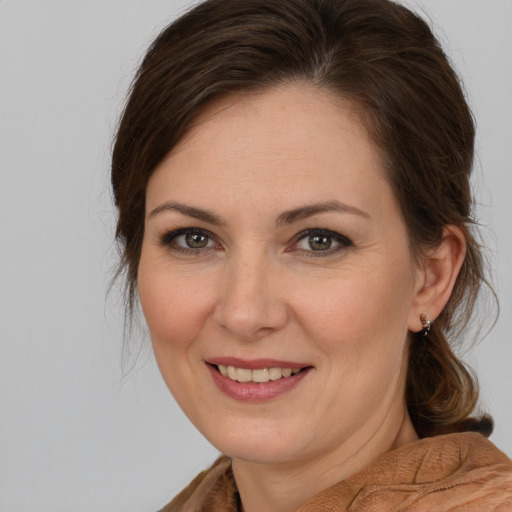 Joyful white adult female with medium  brown hair and brown eyes