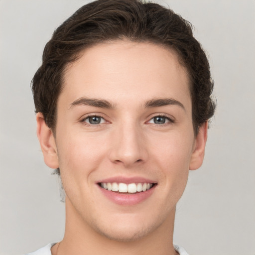 Joyful white young-adult female with short  brown hair and grey eyes