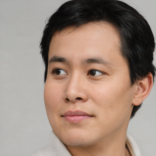 Joyful asian young-adult male with short  brown hair and brown eyes
