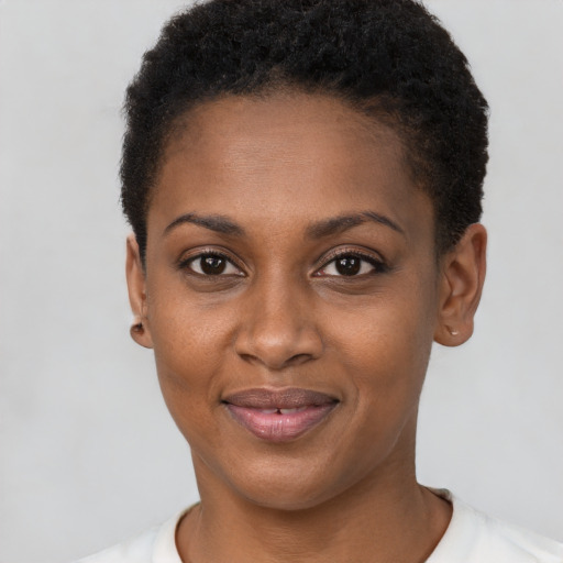 Joyful black young-adult female with short  black hair and brown eyes