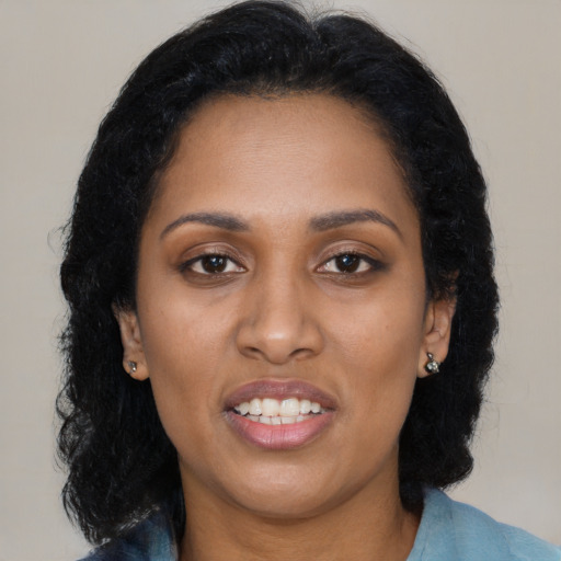 Joyful black adult female with long  black hair and brown eyes