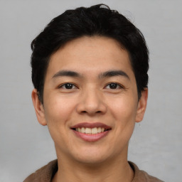 Joyful asian young-adult male with short  black hair and brown eyes