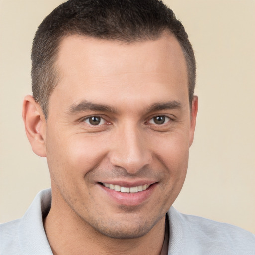 Joyful white young-adult male with short  brown hair and brown eyes